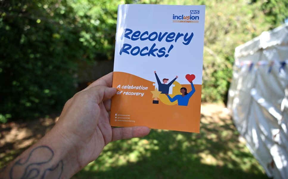 Hand holding Inclusion Isle of Wight Recovery Rocks booklet